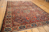 Distressed geometric border and repeating diamond patterns on a vintage Baktiari rug.