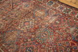 Vintage Baktiari rug, geometric diamond pattern with cherry red, sky blue, green, and even distress.