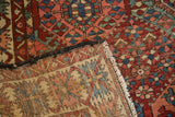 Distressed diamond pattern on a vintage Baktiari rug, revealing natural woven back and fringe.