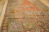 Antique Oushak prayer rug's terra cotta niche, geometric plant motifs, and even pile wear.