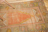 Visible foundation and primitive geometric flower motifs on an antique Oushak rug border.