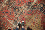Antique Farahan rug detail: aged scalloped medallion in navy and charcoal on a blush field.