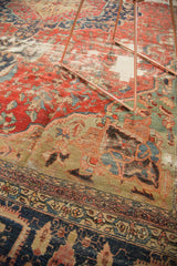 Antique Farahan carpet's curvilinear patterns, blush rose field, time-softened copper green, and navy border.