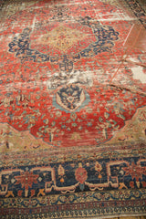 Antique Farahan carpet with worn blush field, deep navy patterns, and varied textile character.