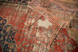 Antique Farahan carpet's ornate blush rose field, showing intricate motifs, pile wear, and exposed foundation.