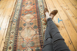 Unique checkered lily lattice pattern across a pale cinnabar antique Hamadan runner.
