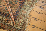 Tattered fringe and intricate border patterns of an antique Persian Hamadan runner.