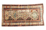 Antique Caucasian rug with geometric triple diamond medallions in sea foam green, red, and dark tones.