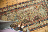 Geometric diamond medallions, bare foundation, and patch on an antique Caucasian rug.