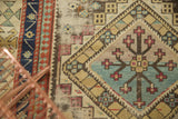 Early 20th century Caucasian rug: geometric diamond motif, floral bursts, and red, blue, beige border.