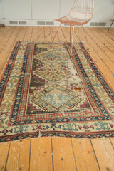 Antique Caucasian rug's lower border showcasing geometric patterns in blue, red, and beige, with short fringe.
