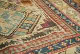 Antique Caucasian rug detail: sea foam, red, beige geometric patterns with a visible patch.
