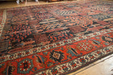 Antique Kurdish Bijar carpet's intricate Garden of Paradise foliage in madder red, navy, and celadon tones.