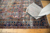 Dark navy border with floral motifs and the rare purple plum field of a distressed Yezd carpet.