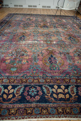 Distressed Yezd rug section: navy blue border, purple plum field, and white fringe.
