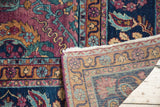 Distressed Yezd carpet's folded corner reveals purple plum pile and hand-knotted reverse foundation.