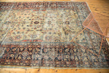 Worn corner of vintage Mahal rug, tattered edge, and intricate dark navy floral border.