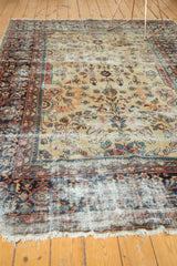 Vintage Mahal carpet, bottom edge with textured fringe and worn areas, red and blue motifs.