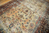Intricate primitive floral drawing on distressed gold and beige field of a vintage Mahal carpet.
