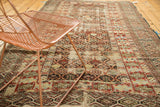 Antique Caucasian carpet showing geometric lattice motif, germinating flowers, reds, browns, and beige.