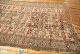 Antique Caucasian carpet detail: geometric lattice motif, wine red, beige, exposed foundation, and tatter.
