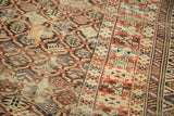 Antique Caucasian carpet detail showing intricate geometric lattice, serrated border, exposed foundation.