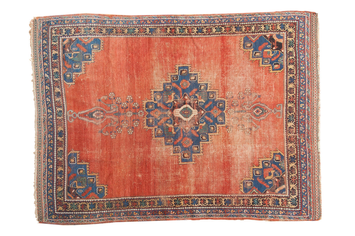Distressed antique Persian Afshar rug, blush terra cotta field, geometric medallion, 4'5" x 5'11".