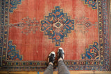 Distressed antique Afshar rug, showing blush terra cotta field with visible patina and wear.