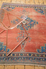 Distressed blush terra cotta field of an antique Afshar rug with time-softened geometric blue motifs.
