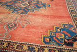 Distressed blush terra cotta field with vivid blue geometric Afshar rug border.