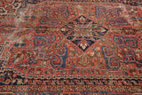 Geometric vinery and budding flowers on a vintage Heriz rug, with areas of wear.