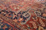 Vintage Heriz rug detail: brick red, navy, oxidized green geometric vinery with budding flowers.