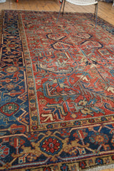 Distressed vintage Heriz rug, rich brick red field, exaggerated teal leaves, and navy blue border.