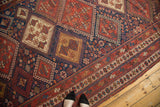Antique Afshar rug, geometric diamond pattern in madder red, indigo, and saffron tones.