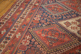 Rich indigo and madder root red geometric tribal motifs on an antique Afshar carpet.