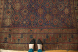 Antique Belouch carpet featuring intricate geometric patterns in navy, madder red, and chocolate brown border.