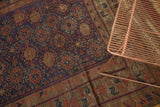 Geometric field and madder red border detail on an antique Belouch carpet, with time-softened pile.