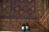Antique Belouch carpet showing rich navy, madder red geometric pattern and time-softened patina.