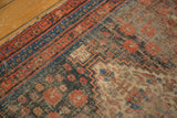Vintage Afshar rug corner, brick red geometric borders, navy floral motifs, worn foundation with zigzag pattern.