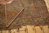Antique Persian camel hair rug close-up, revealing worn foundation, frayed edge, and pomegranate motifs.