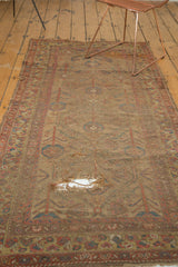 Antique Persian camel hair runner: prominent hole revealing foundation and faded botanical pattern.