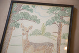 Lower right of framed embroidery, showing deer's brown stitches, green foliage, tree.