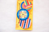 Mid Century Spin the Tops toy close-up, showing colorful airplane and striped designs.