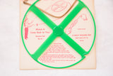 Bright green Mid Century Pearson's Boomerang Toy with red instructions on beige packaging.
