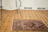 Sarouk rug's bold burgundy medallion, floral field, with ivory, blush, and pistachio green.