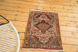 Vintage Sarouk rug mat with bold scrolling medallion, floral field, and blanched ivory tones.