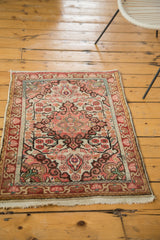 Vintage Sarouk rug's lower border and fringe, showcasing blush, burgundy, and ivory floral tendrils.