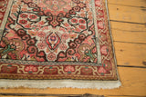 Secured ivory fringe with dark wine red and blush floral border detail on vintage Sarouk.