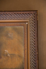 Upper right corner of antique painting's carved wood frame showing braided pattern, chipping, and canvas hole.