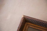 Upper right corner of antique painting frame with visible wood chipping and ornate carved detail.